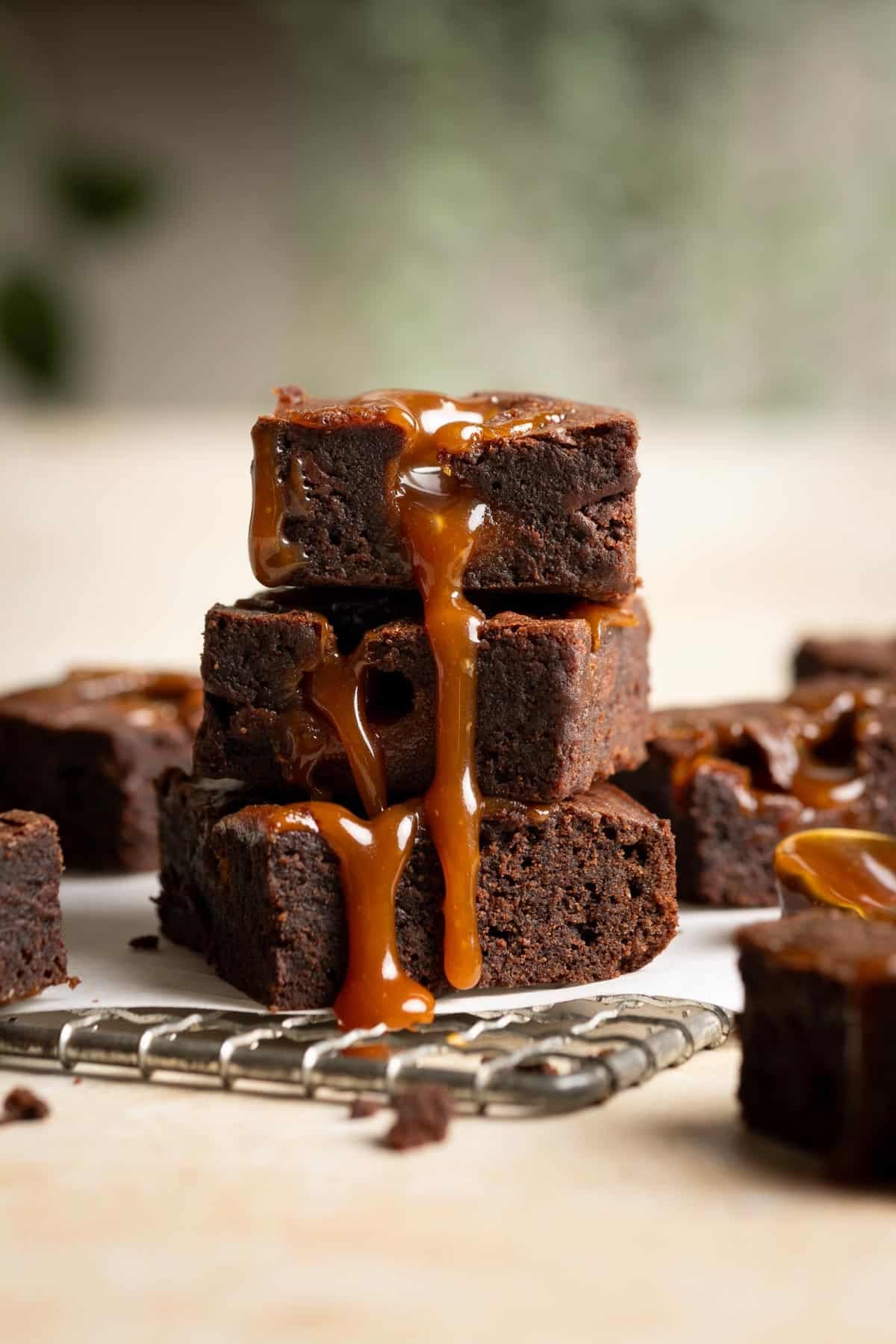 Stack of salted caramel brownies drizzled with caramel